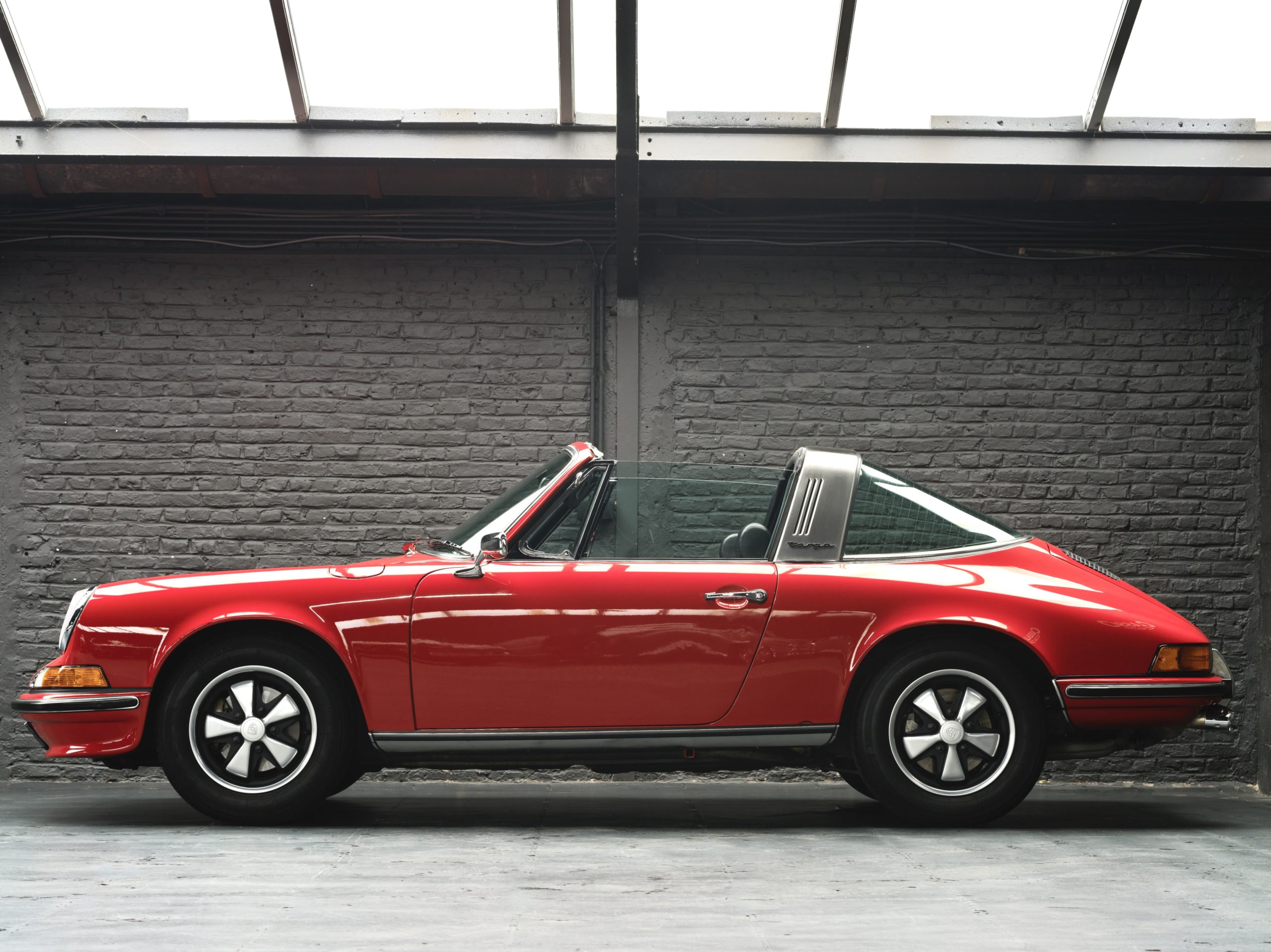 Exterior of a 1973 Red Bahia Porsche 911 2.4E Targa fully restored in 2019 with 12.685 km and black leather interior