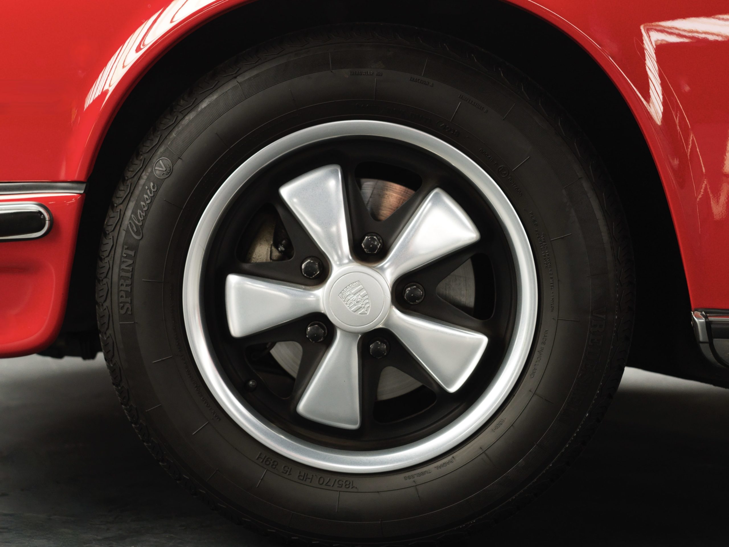 wheel of a 1973 Red Bahia Porsche 911 2.4E Targa fully restored in 2019 with 12.685 km and black leather interior