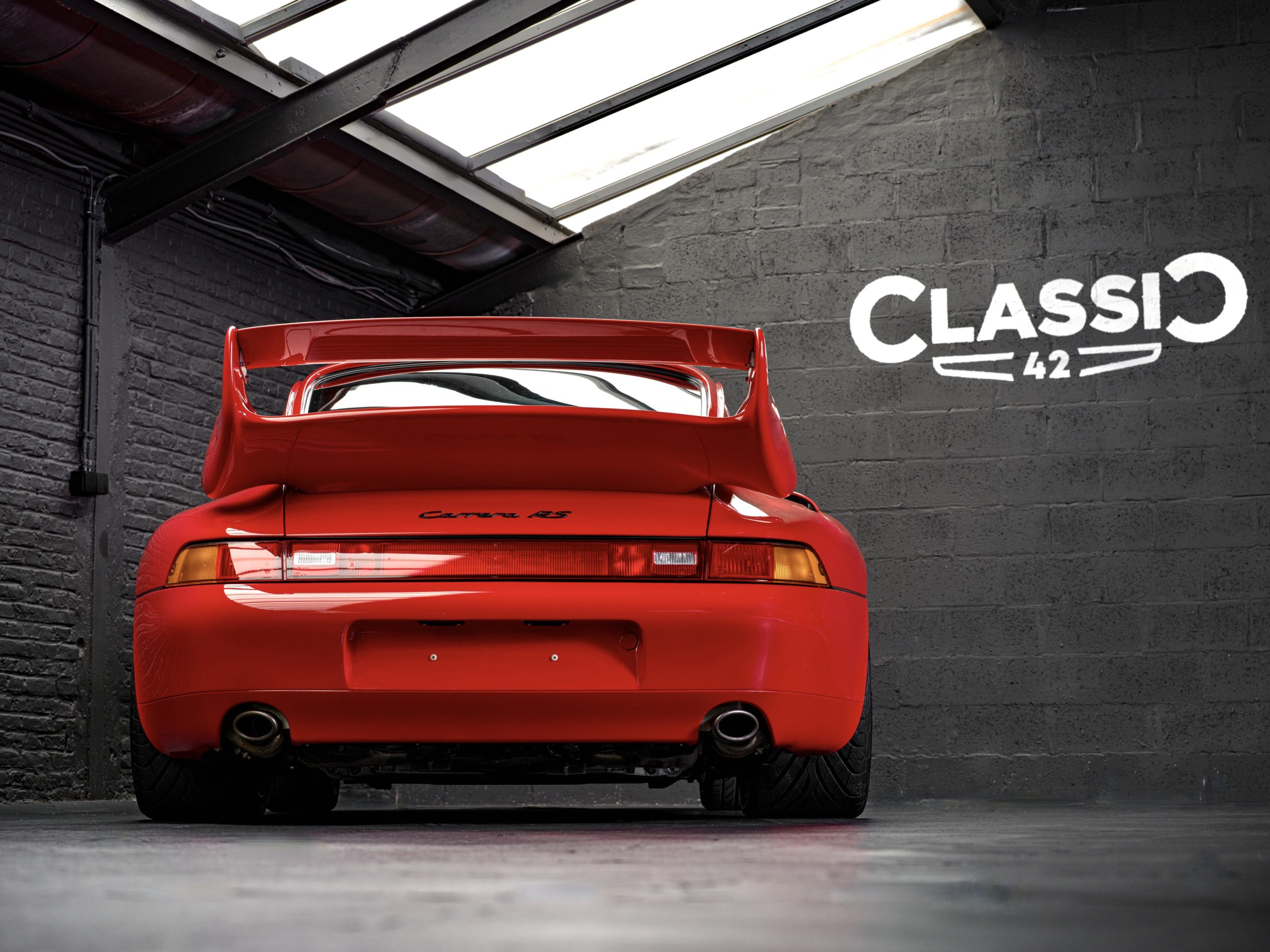 vue arrière basse d'une Porsche 993 RS Clubsport rouge de 1996 occasion chez classic 42