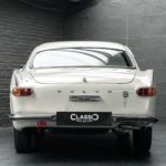 vue arrière d'une Volvo 1800S de 1965 blanc cassé intérieur rouge en vente chez Classic 42